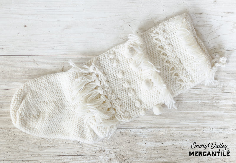 boho hand knit Christmas stocking with tassels, poms, and fringe