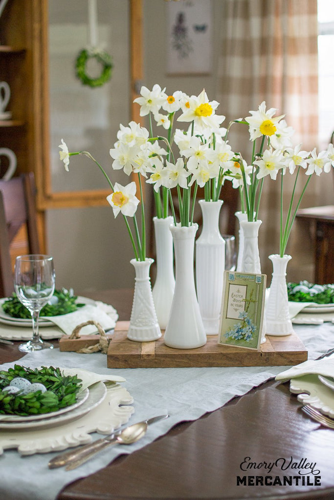 rustic wood cheese board with rope handle and milk glass vases