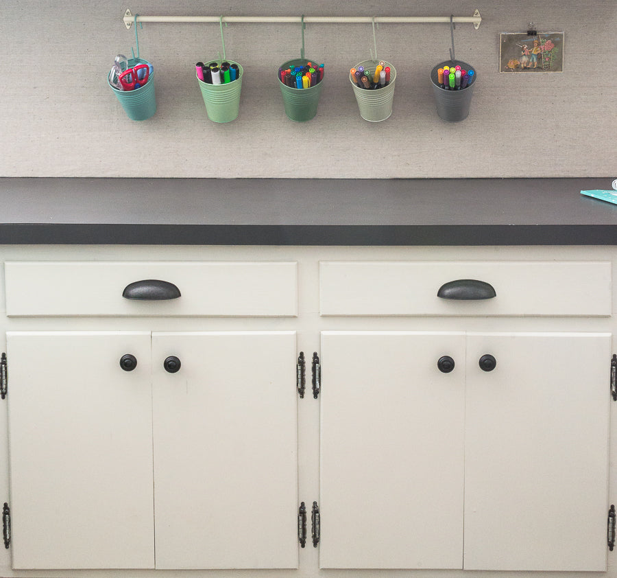 pastel pots hanging on a rod for studio or craft room organization