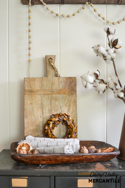 farmhouse style wooden cheese board and fall preseved boxwood wreath