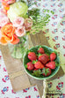 rustic wooden cutting board with bowl of strawberries
